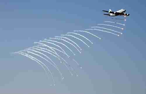 Japanese patrol plane launches anti-missile flares during a fleet review in 2015 (AFP)