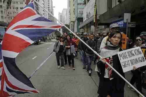 In a previous protest, girl holds British flag and placard reading 'Make Hong Kong Great Britain Again' (SCMP)