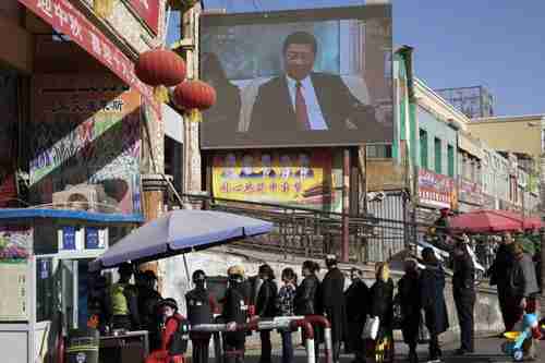 Uighurs pass through security checkpoint in Xinjiang province (AP)