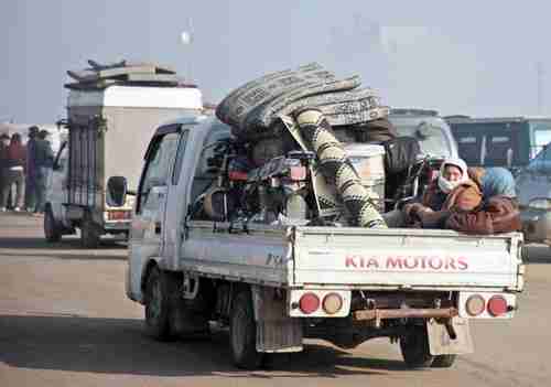 Displaced Syrians in Idlib carry their belongings and try to escape al-Assad's violence by fleeing to the Syria-Turkey border (AFP)