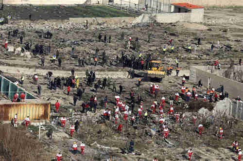 This image from Wednesday shows the crash site with a bulldozer burying the evidence so that Iran can deny culpability. (AP)