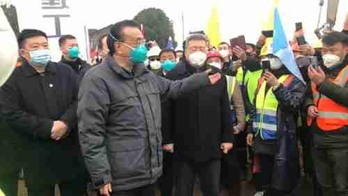 China's premier Li Keqiang, wearing a green medical mask, meets hospital workers in Wuhan on January 29 (AP)