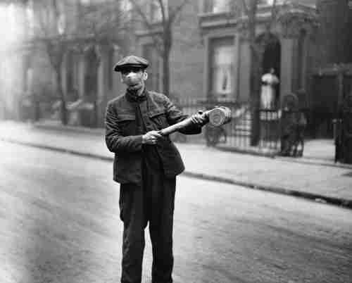  A man wearing a mask uses a pump to spray an unknown 'anti-flu' substance in the United Kingdom, following the Spanish flu pandemic (Getty)