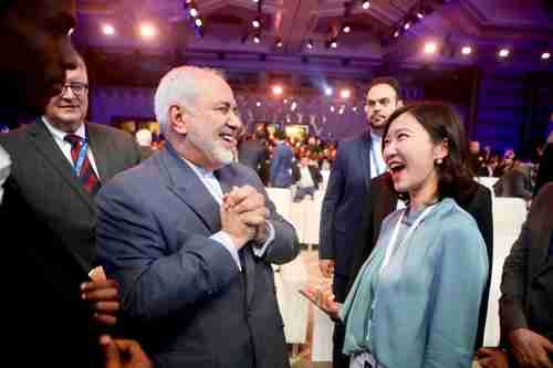 A hearty laugh is shared in December by Iran's foreign minister Javad Zarif, left, and Miao Lu, secretary-general of Center for China & Globalization (AFP)