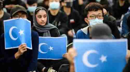 A rally in Hong Kong in December last year in support of Uighurs in Xinjiang province.  In the back, one officer draws a pistol.  (AFP)