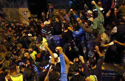 Soldiers and civilians gather at site of Thursday's suicide bombing in Beirut (AP)